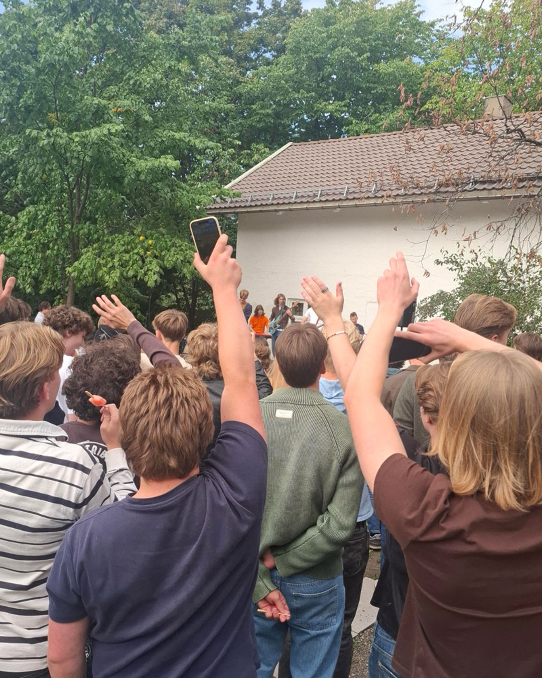 en gruppe mennesker som rekker opp hånden