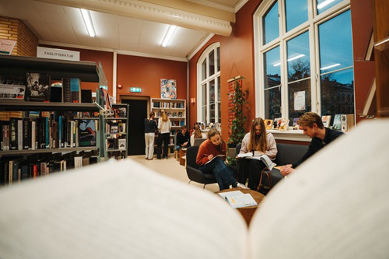 en gruppe mennesker som sitter i et bibliotek