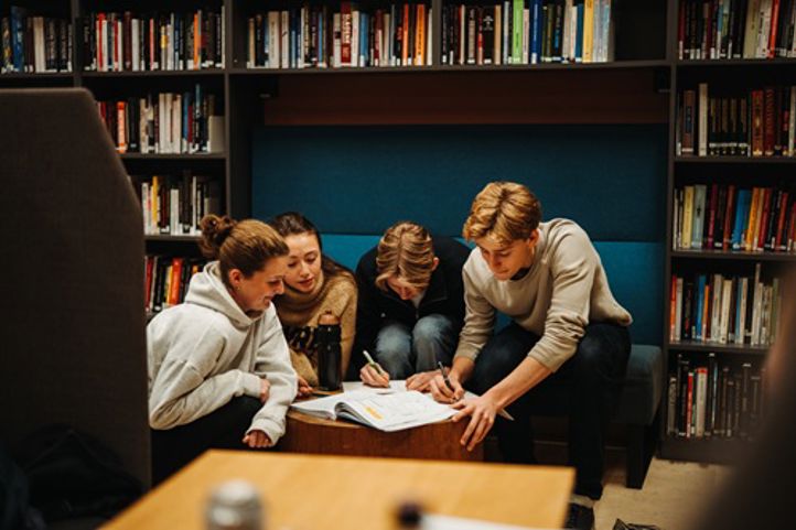 en gruppe mennesker som sitter i et bibliotek