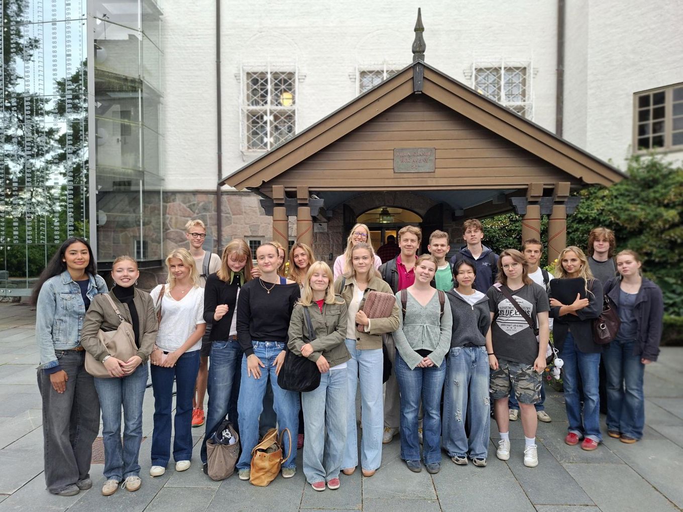 en gruppe mennesker som poserer for et bilde foran en bygning