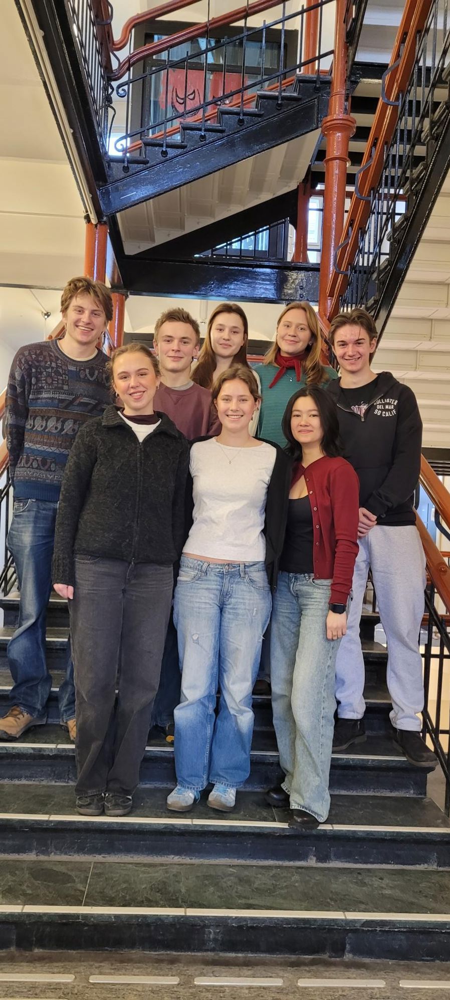 en gruppe mennesker som poserer for et bilde på en trapp