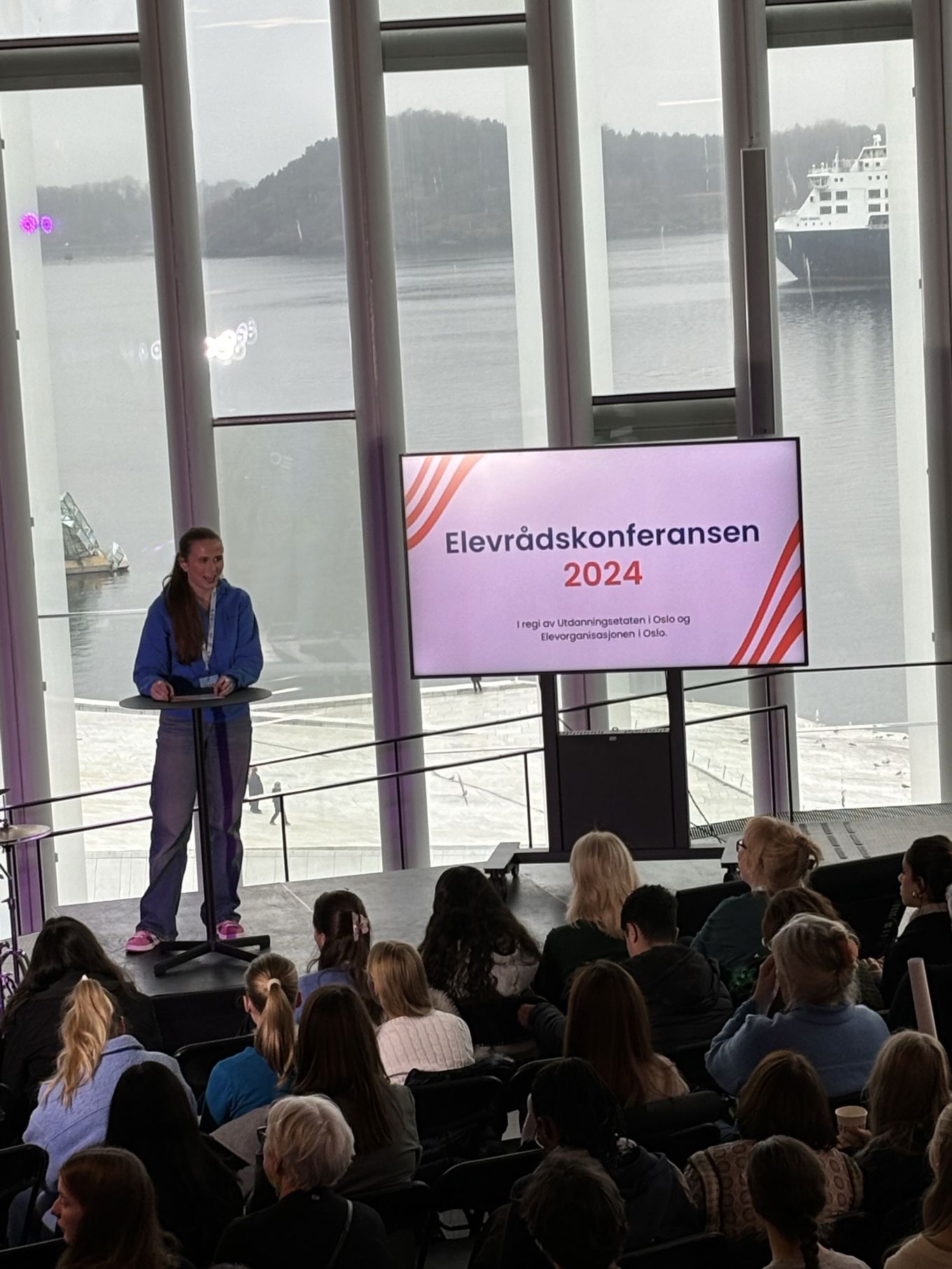 en person som står på en scene foran en folkemengde