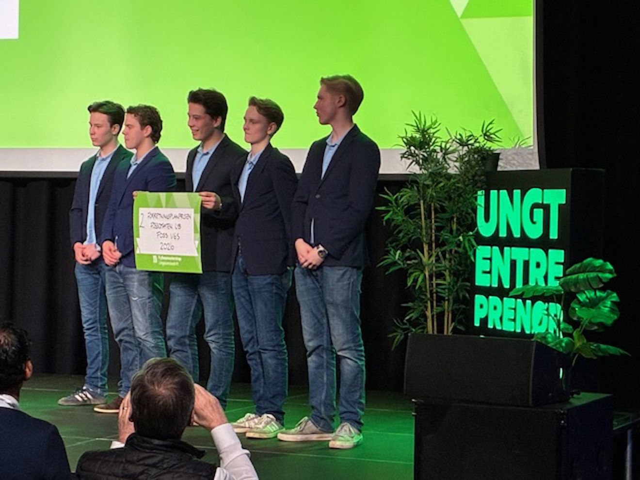 Foto: Foss vgs en gruppe menn som står på en scene og holder et skilt