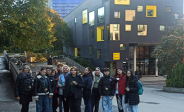 en gruppe mennesker som poserer for et bilde foran en bygning