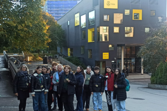 en gruppe mennesker som poserer for et bilde foran en bygning