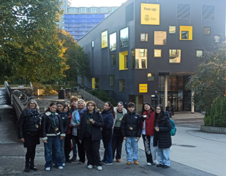 en gruppe mennesker som poserer for et bilde foran en bygning