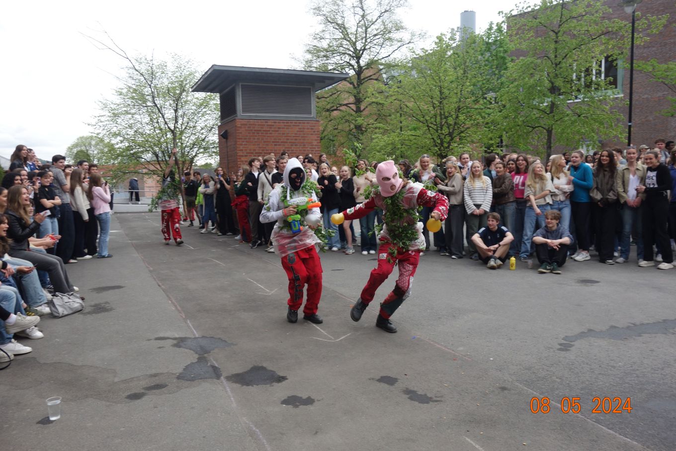 To personer i klær som danser foran en folkemengde