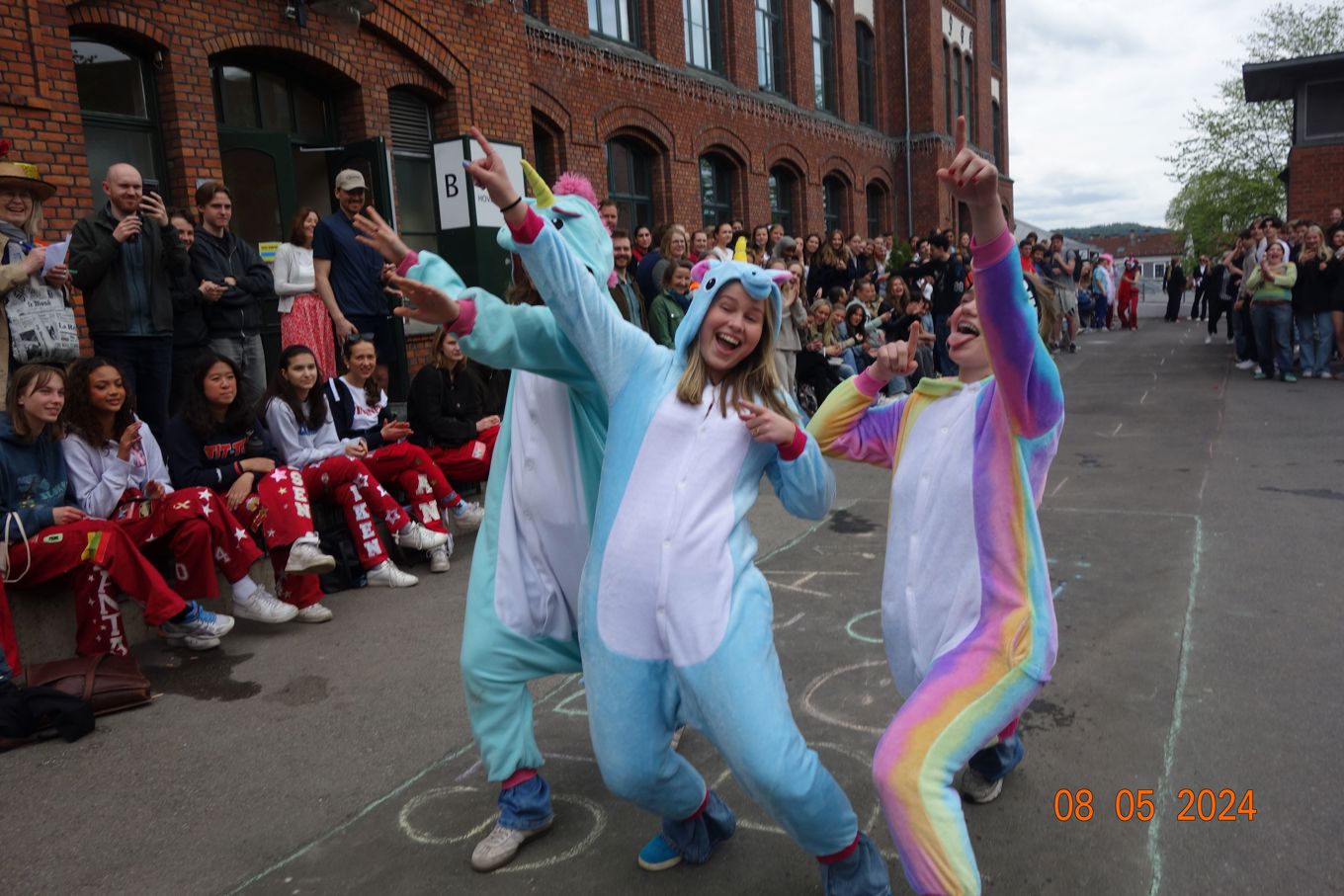 Tre personer som danser foran en mengde mennesker