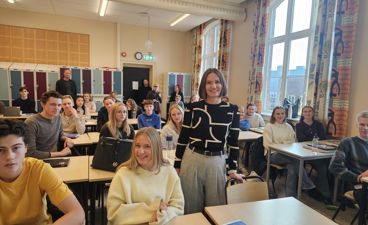 en gruppe mennesker som sitter ved bord