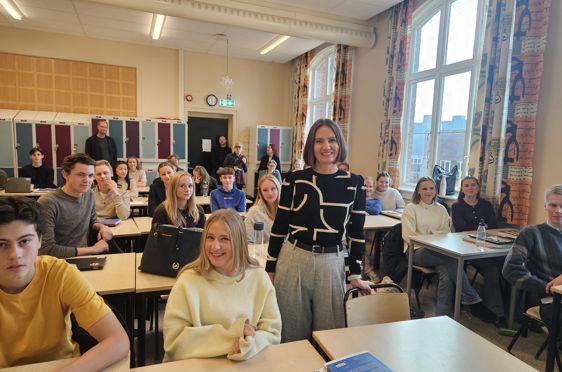 en gruppe mennesker som sitter ved bord