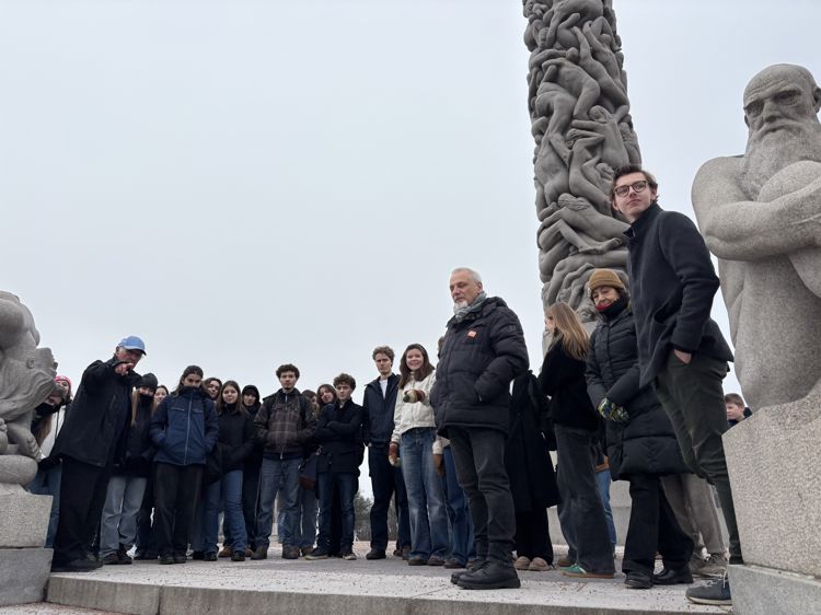 en gruppe mennesker som poserer for et bilde foran en statue