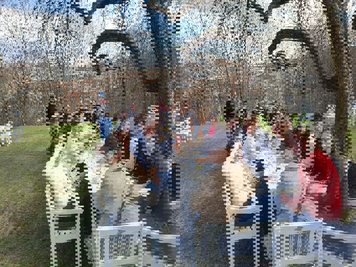 En gruppe mennesker som sitter rundt et bord ute