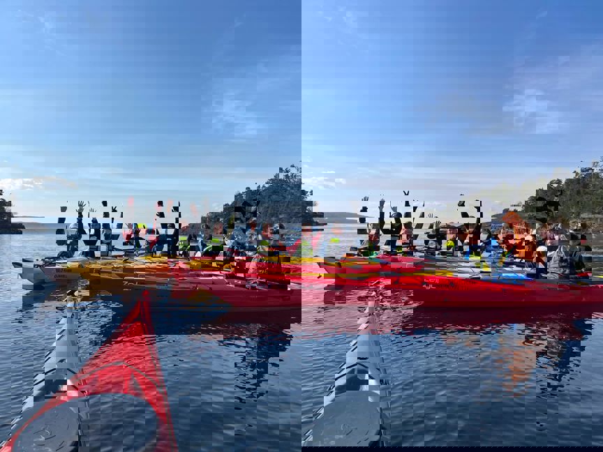 En gruppe mennesker i kanoer