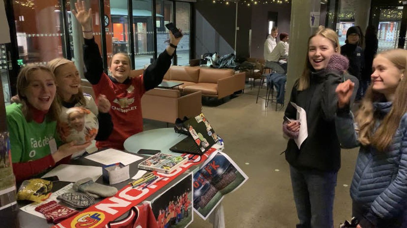 en gruppe mennesker som står rundt et bord med bøker og en eske