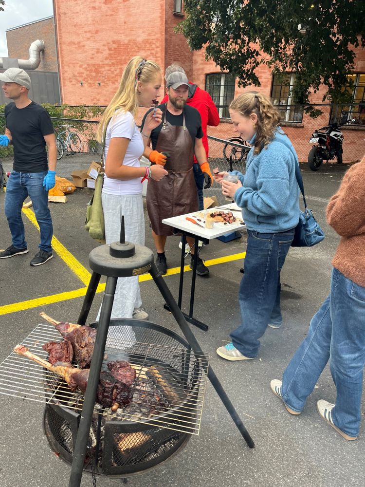 en gruppe mennesker som står rundt et bord med en hund på
