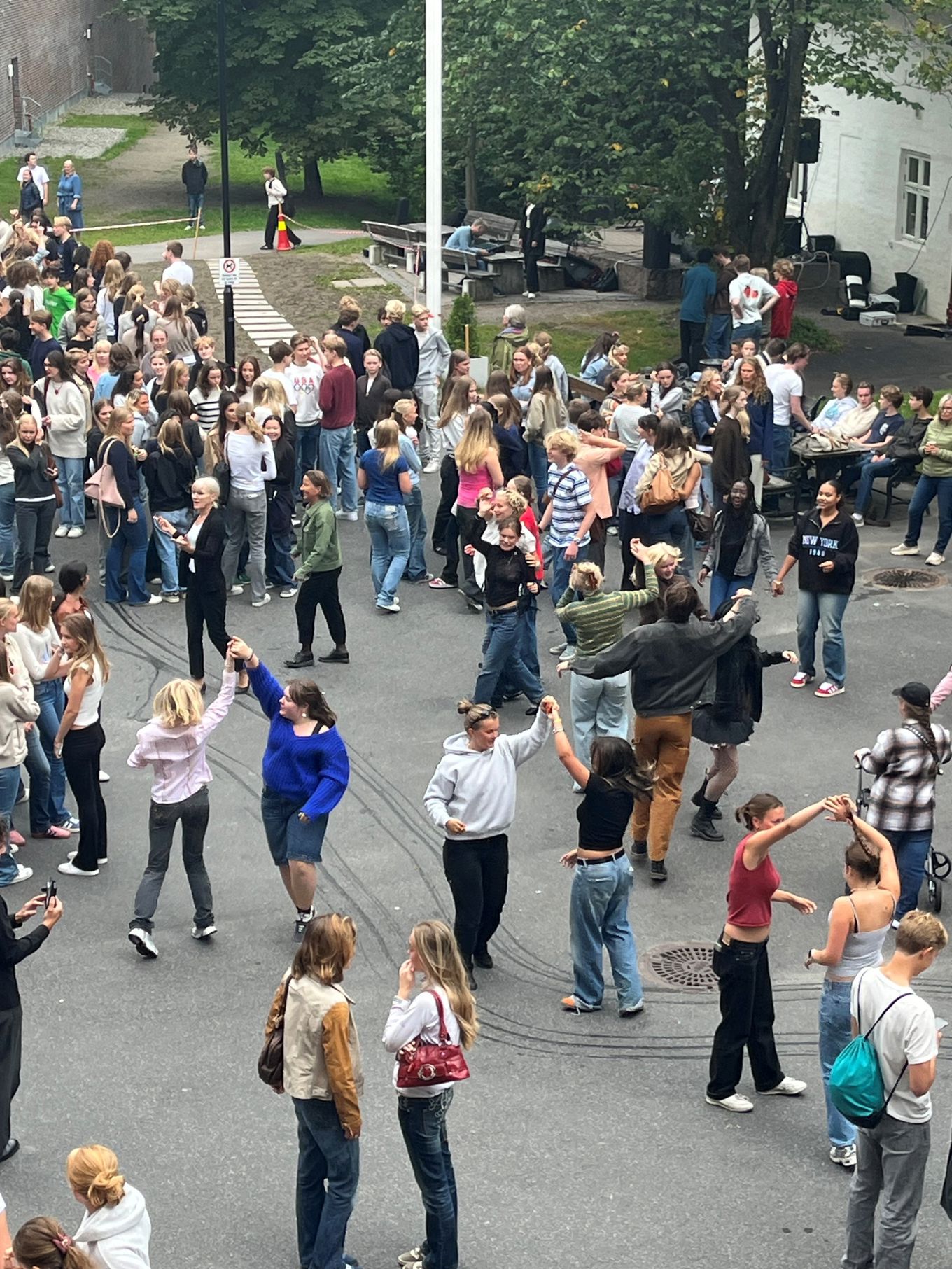 en gruppe mennesker som står på et fortau