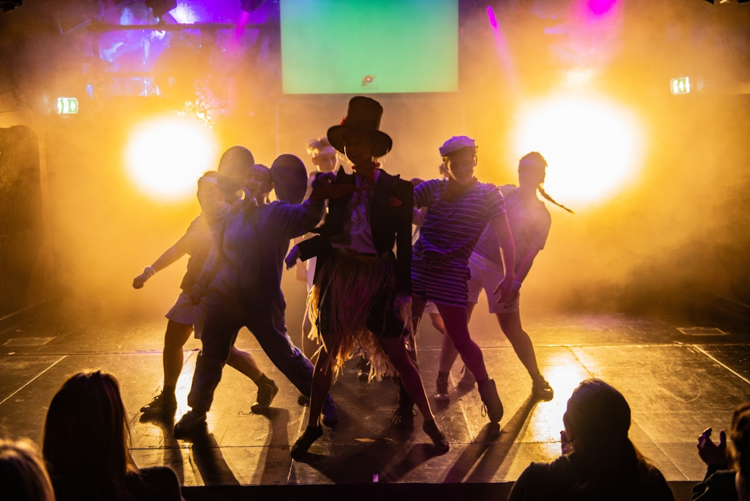 en gruppe mennesker som danser på en scene